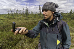 Tim Irvin takes a compass bearing while doing field research in Ontario's Far North.